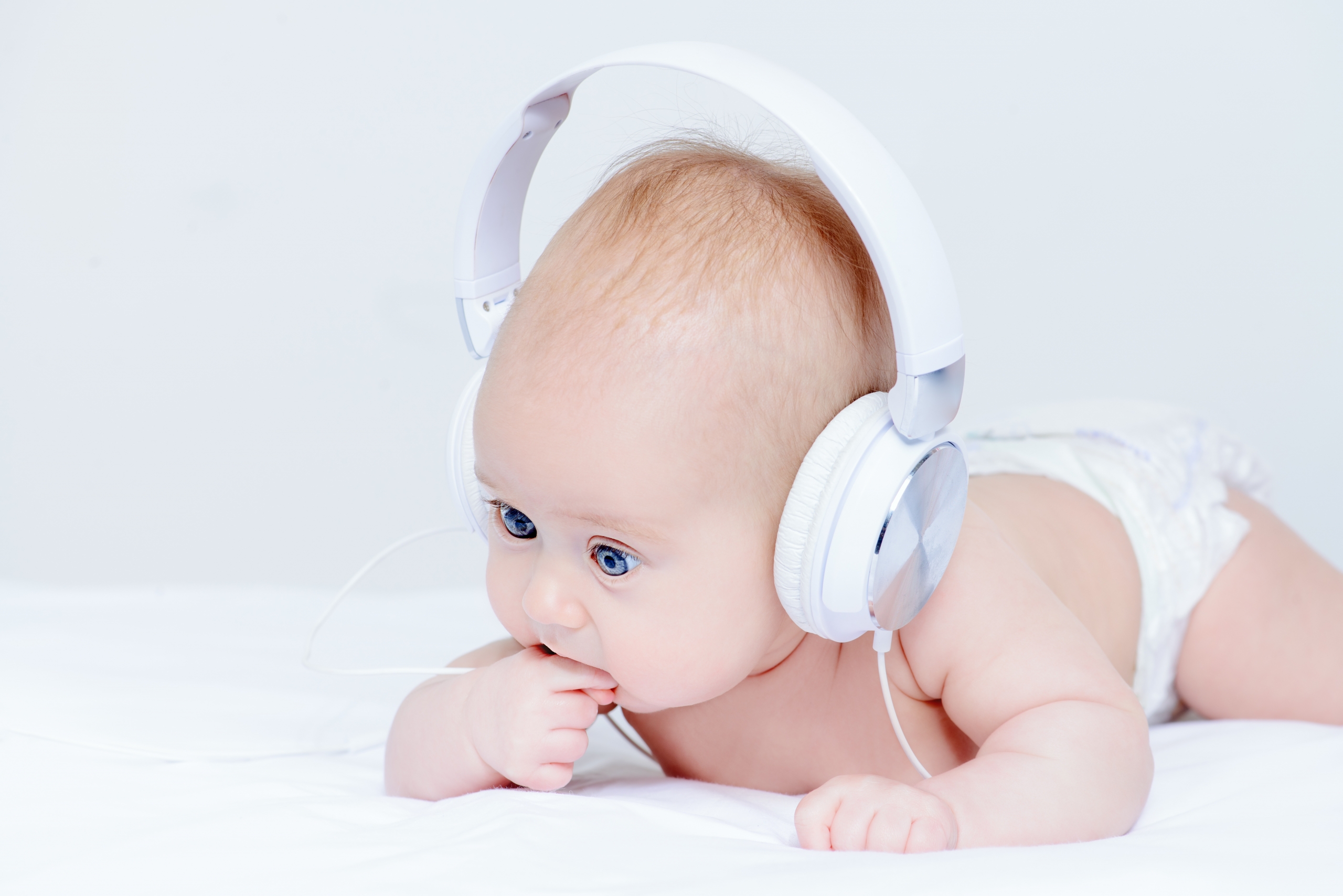 Three-month-old baby listening to music in headphones.