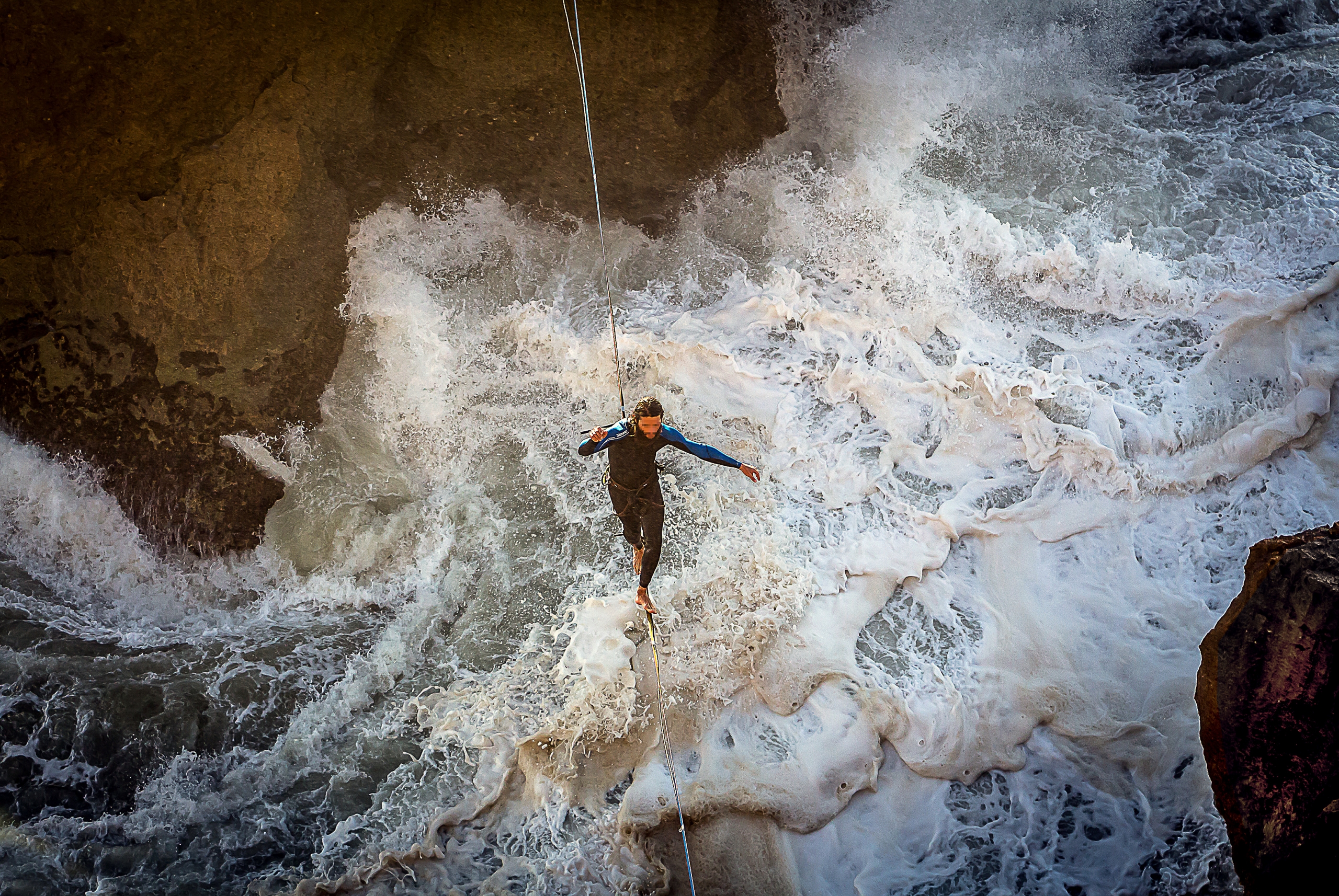 Man Balancing On a Steel Wire Over Agitated Sea