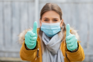 woman with mask and gloves showing thumbs up. Coronavirus pandemic alert. Covid-19