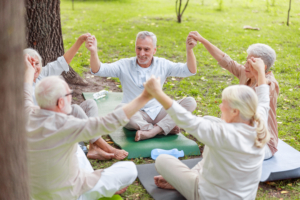 Smiling older people sitting in circle and holding hands