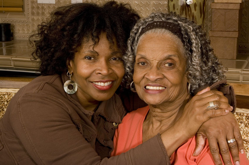 Mature African American mother hugging adult daughter