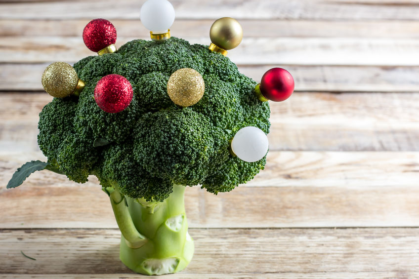 Healthy eating, fresh green broccoli tree decorated with Christmas balls on rustic wooden background