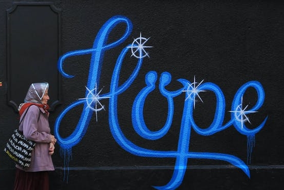 Hope sign on wall with older woman approaching