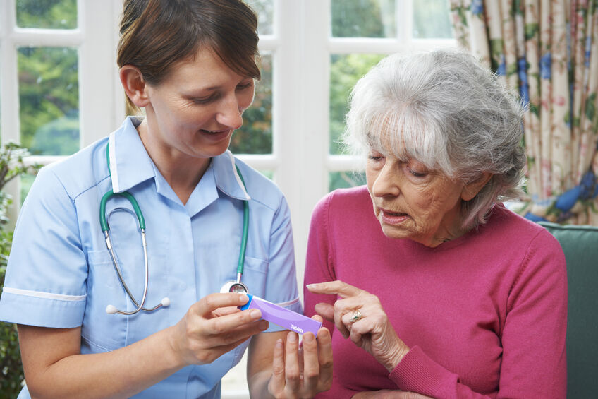 Nurse Advising Senior Woman On Medication At Home