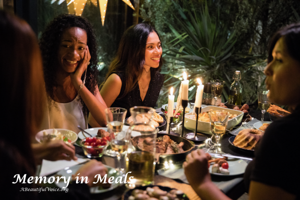 The author's family seated together at dinner table sharing stories, memories, and food.