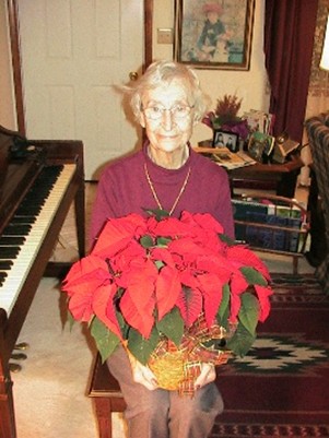 This Christmas photo was taken 10 years following my mother's diagnosis of Alzheimer's. That evening, we were energized by having sung many Christmas carols at the piano. I suggested we take her Christmas photo. Without saying a word, she picked up the poinsettia from the piano and sat down next to the piano ready to be photographed. This showed her quick response, understanding, and desire to get into the action. She liked being photographed.