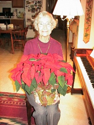 This Christmas photo was taken 10 years following my mother's diagnosis of Alzheimer's. That evening, we were energized by having sung many Christmas carols at the piano. I suggested we take her Christmas photo. Without saying a word, she picked up the poinsettia from the piano and sat down next to the piano ready to be photographed. This showed her quick response, understanding, and desire to get into the action. She liked being photographed.