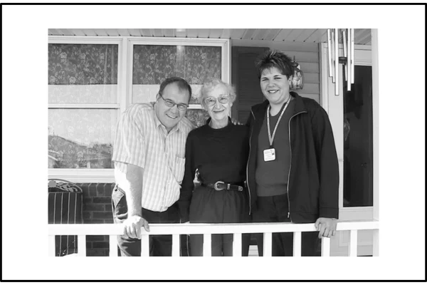 Black/white photo of the hospice chaplain and the hospice social worker standing on each side of my mother who was a recipient of hospice care with a diagnosis of Alzheimer's. They are standing on our front porch following a session of what might be called LAUGHTER THERAPY. They laughed the entire 45 minutes at our kitchen table when reading jokes which the chaplain had printed out from the internet. It was great therapy for my mother who had a wonderful sense of humor and loved to laugh at the chaplain's jokes. Just an amazing experience and such a good memory! :)